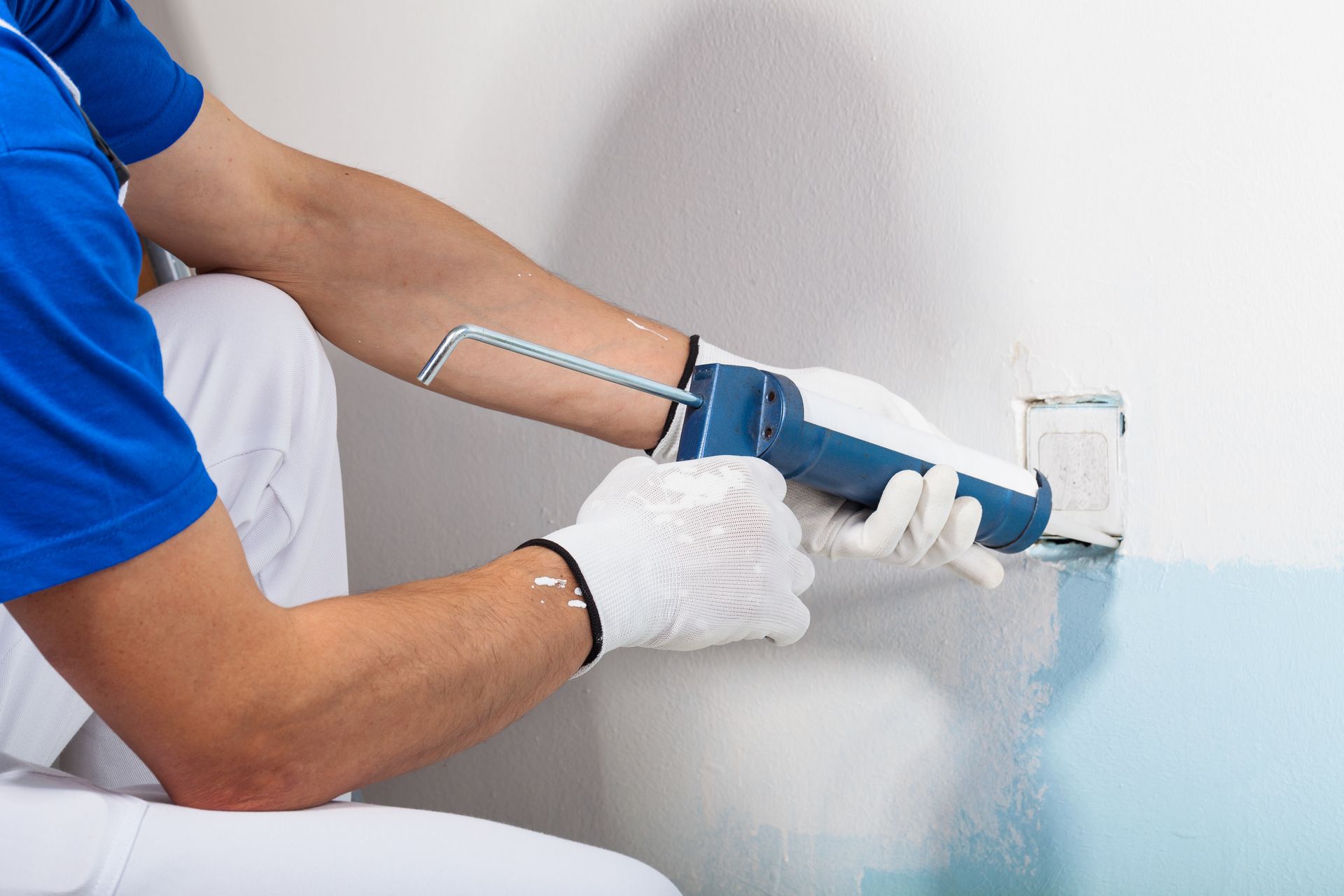 Professional Workman Applying Silicone Sealant With Caulking Gun