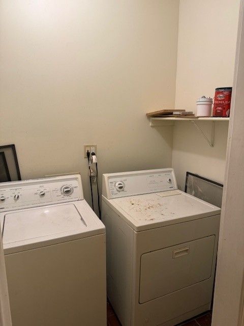 White washer and dryer in a laundry room with a shelf holding items.