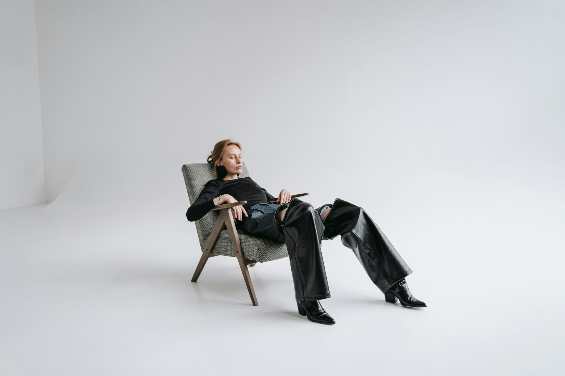 A woman is sitting in a chair with her legs crossed.