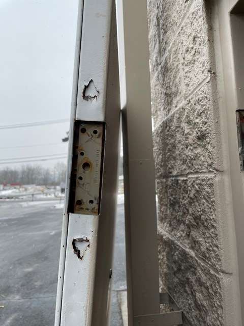 A close up of a door with a brick wall in the background