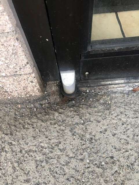 A white object is sitting on the ground next to a door.
