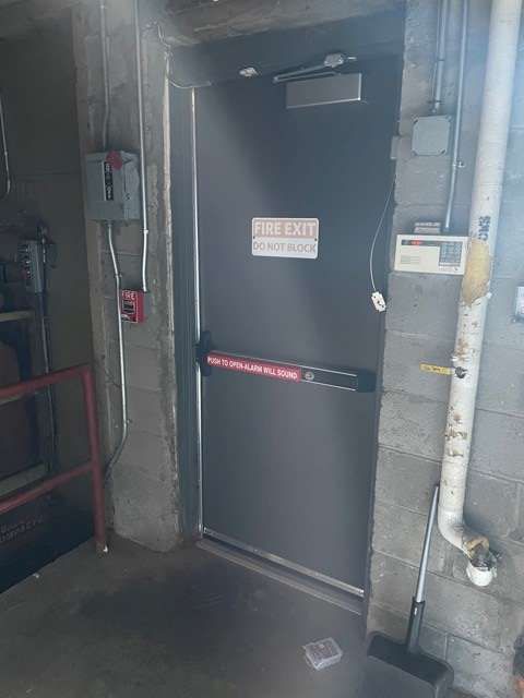 There is a fire exit door in the corner of a building.