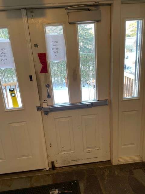 A white door with a black mat in front of it.