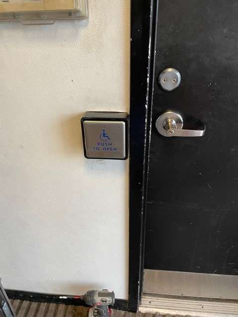 There is a button on the wall next to a door.