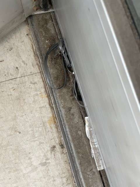 A close up of a sliding glass door on a tiled floor.