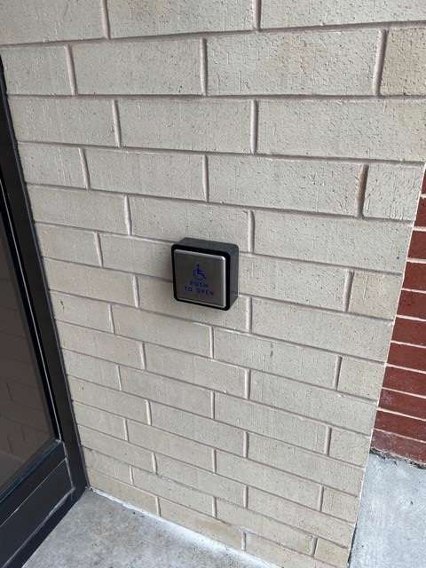 A brick wall with a push button on it