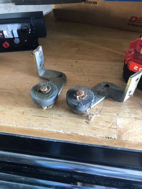A pair of metal brackets are sitting on top of a wooden table.