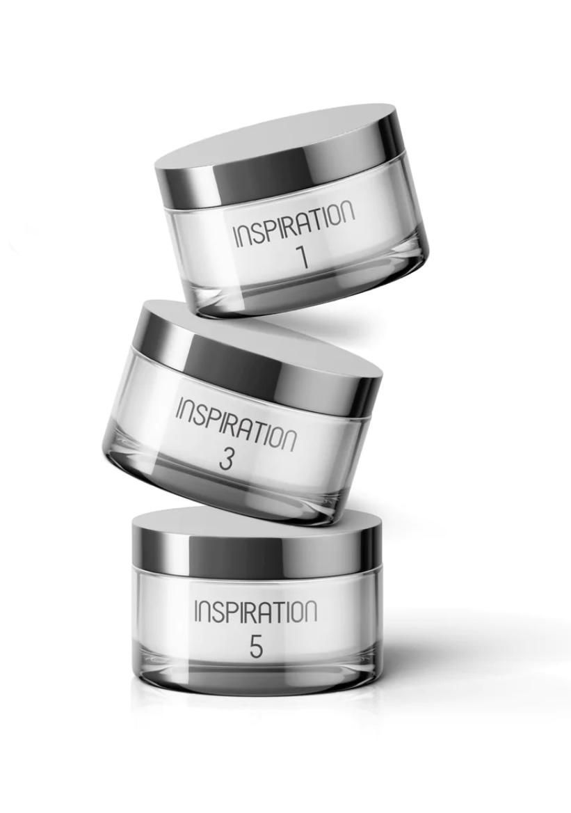 three jars of powder are stacked on top of each other on a white background .