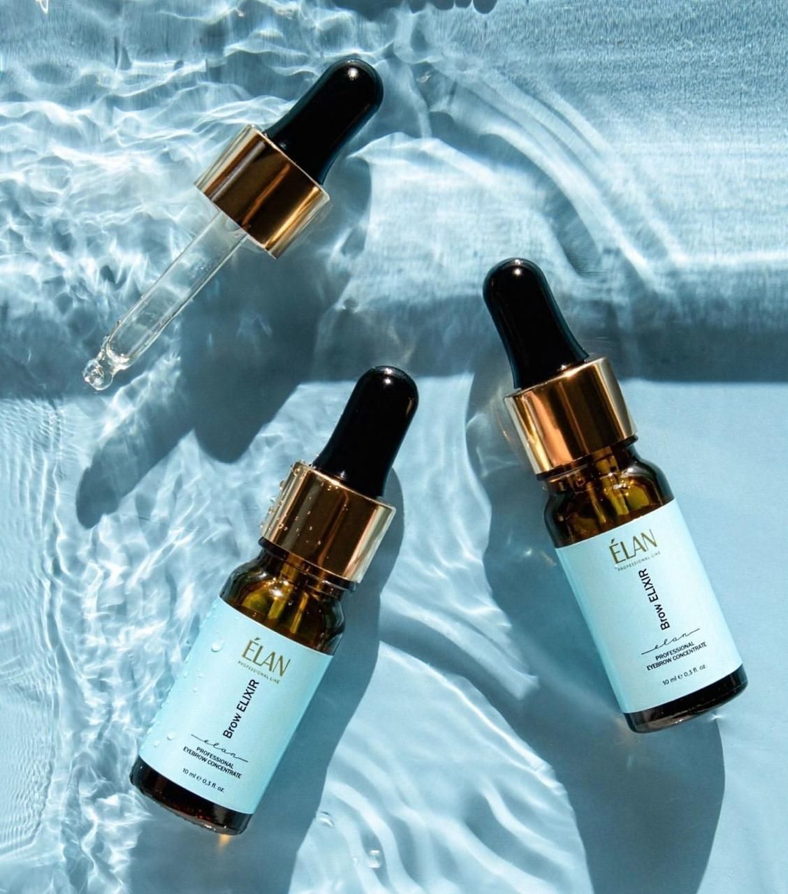 three bottles of elan are sitting on top of a body of water