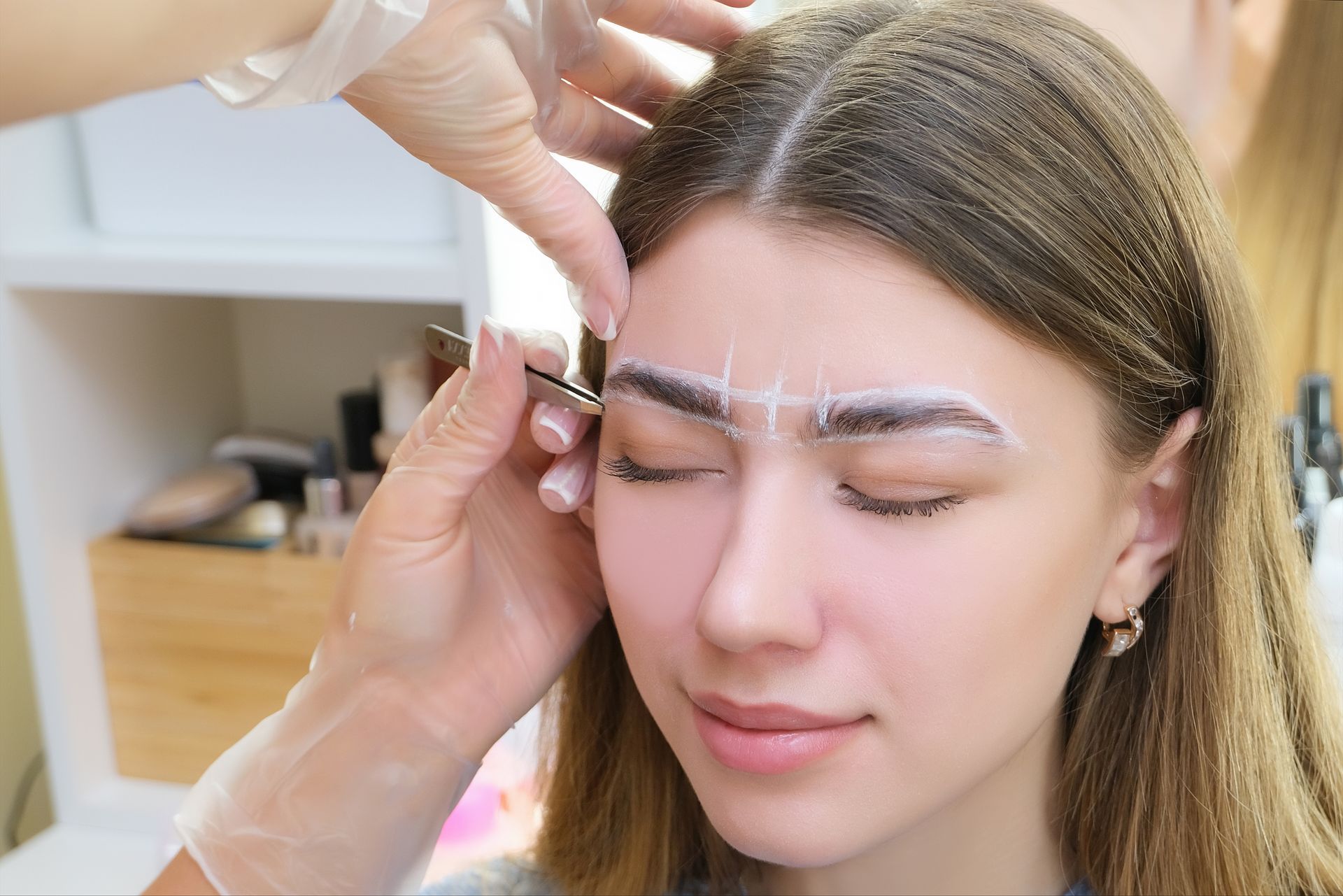 a woman is getting her eyebrows painted in a salon .