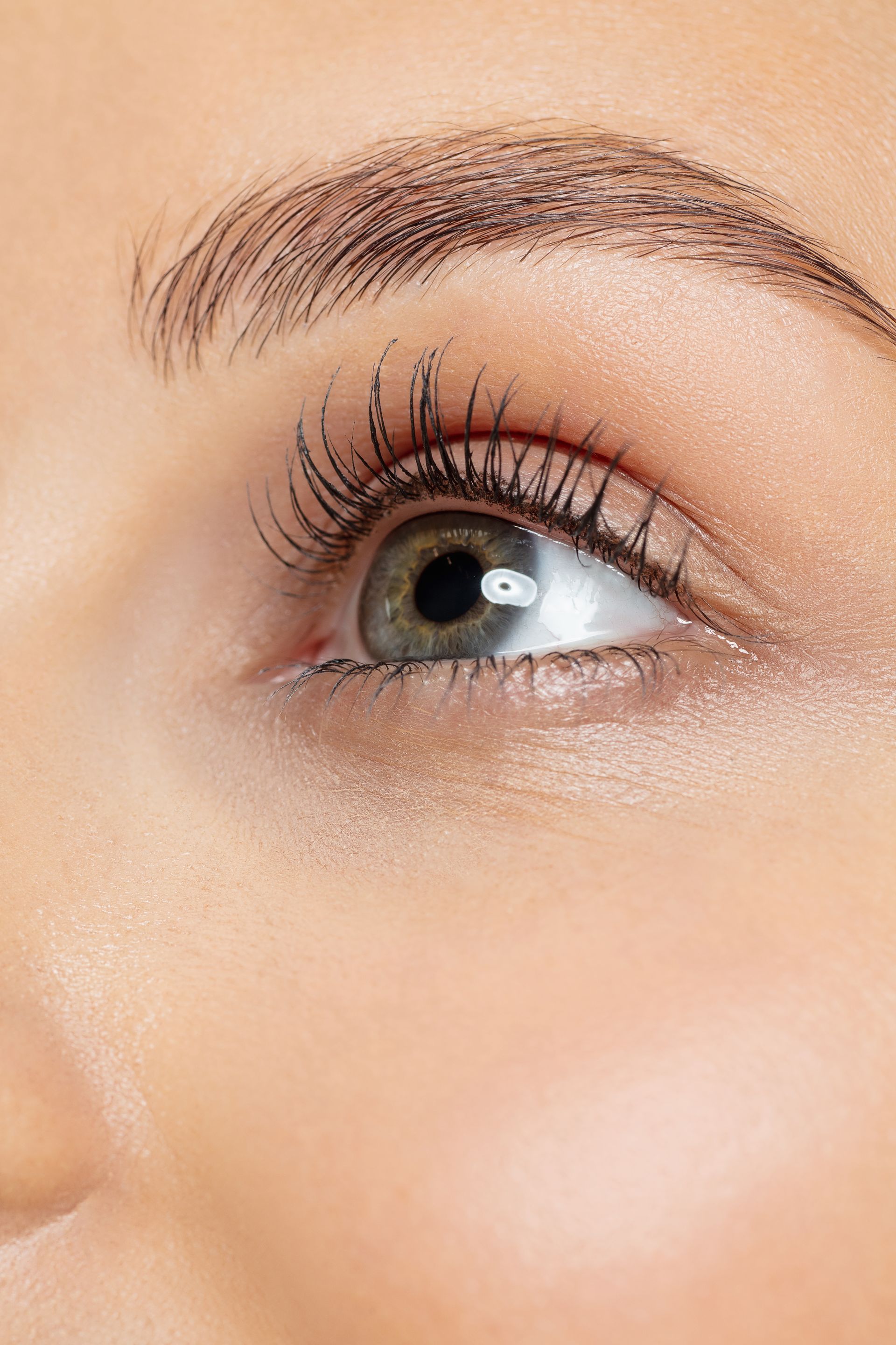 a woman is holding two mascara brushes in her hands .