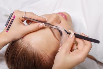 a woman is getting her eyelashes done at a beauty salon .