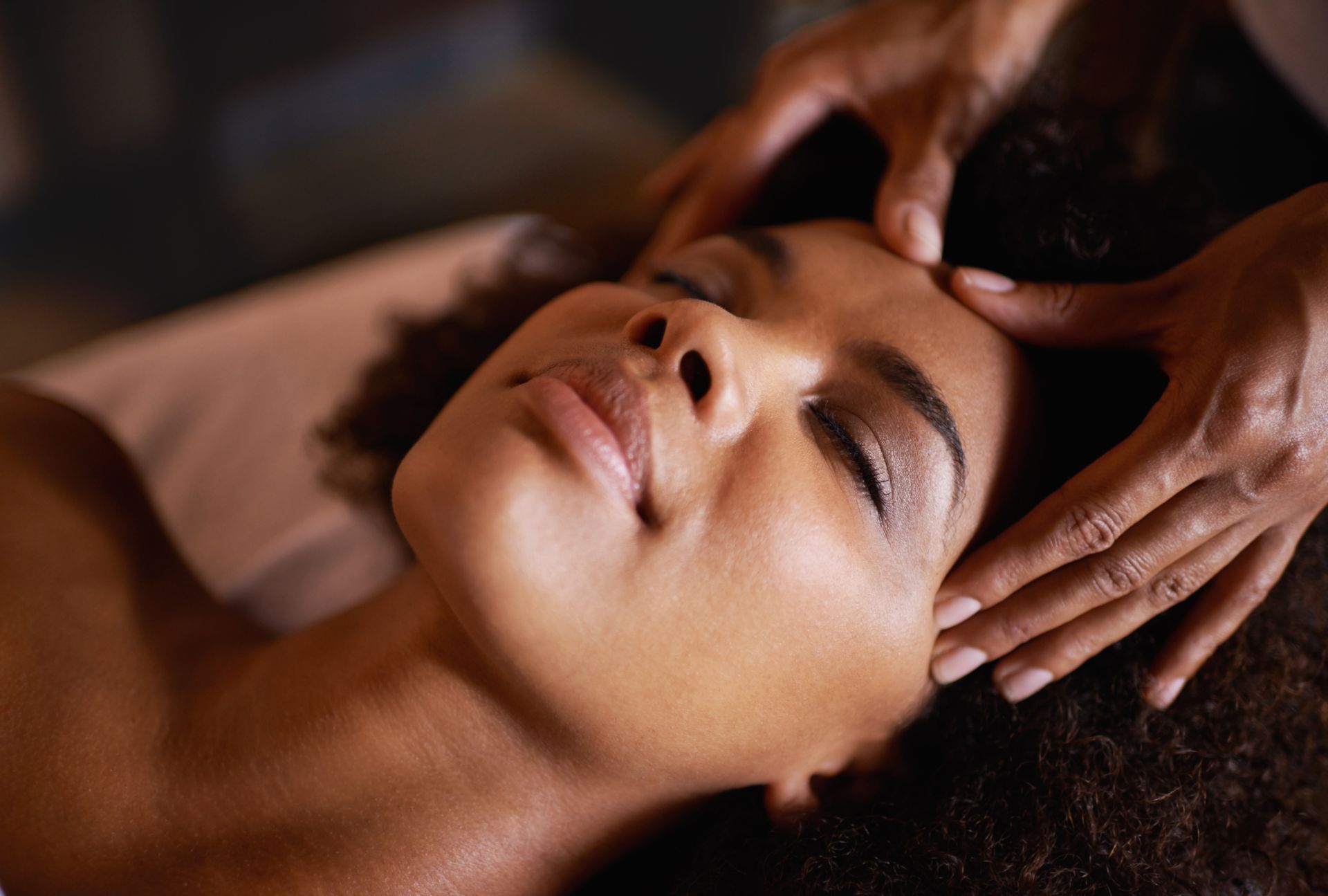 A woman is getting a head massage at a spa.