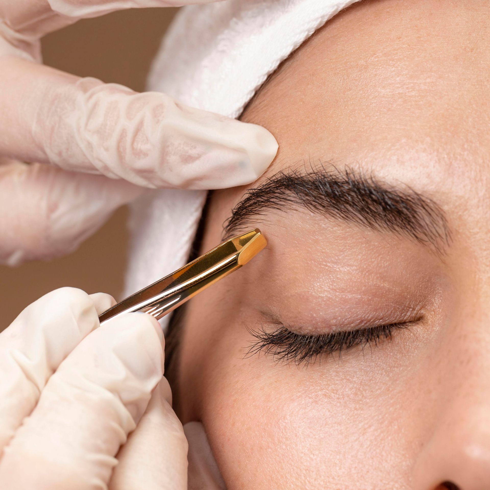 a woman is getting her eyebrows done with a brush