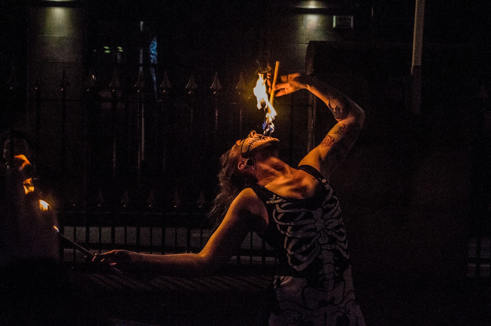 Colour photo of Mia Meow fire eating in a skeleton halloween costume and face paint by Powederkeg Photography