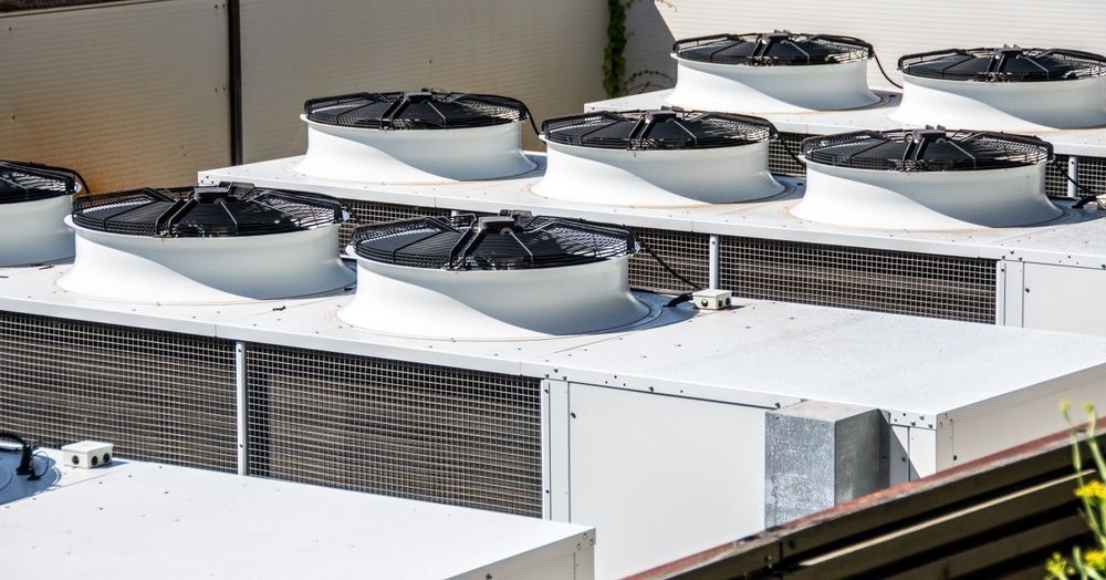 White rooftop air conditioning units with black fans.