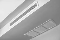 Two rectangular air vents installed in a white ceiling.