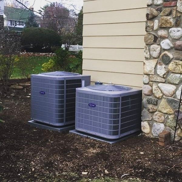 Two carrier air conditioners on the side of a house