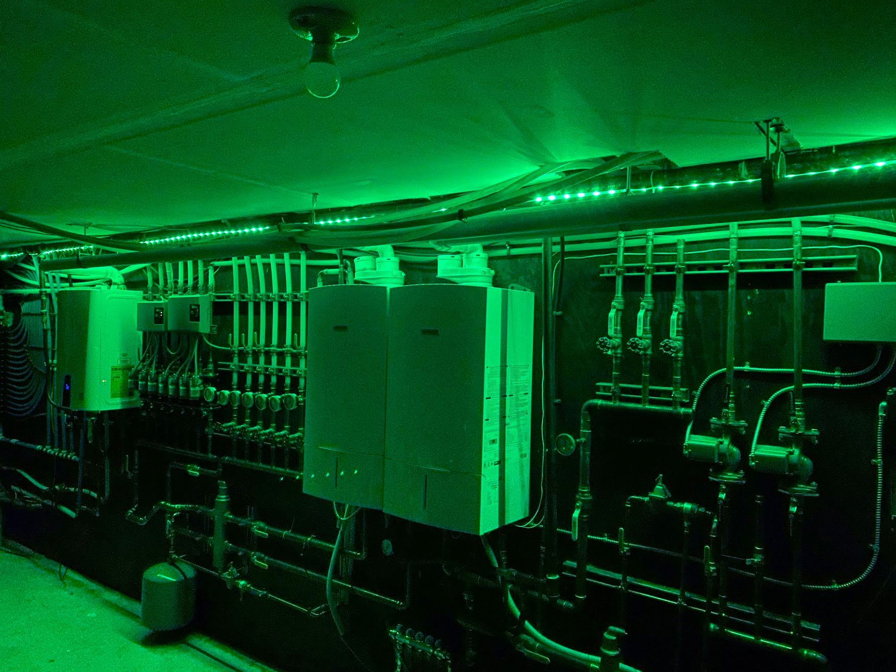 A dark room with green lights on the walls and ceiling