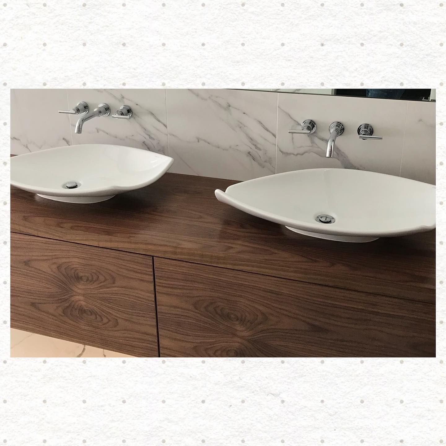 A bathroom with two sinks and a mirror