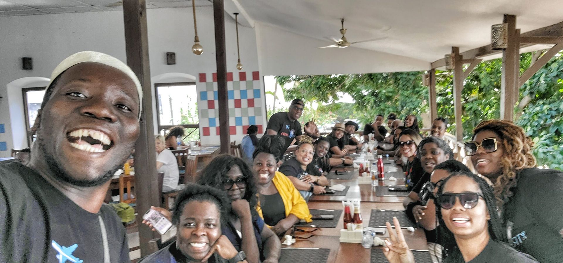A group of people are sitting at a long table in a restaurant.