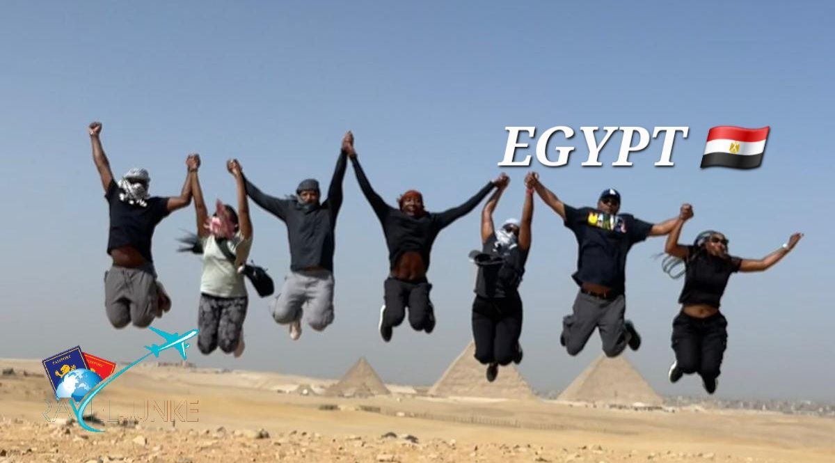 A group of people are jumping in the air in front of the pyramids in egypt