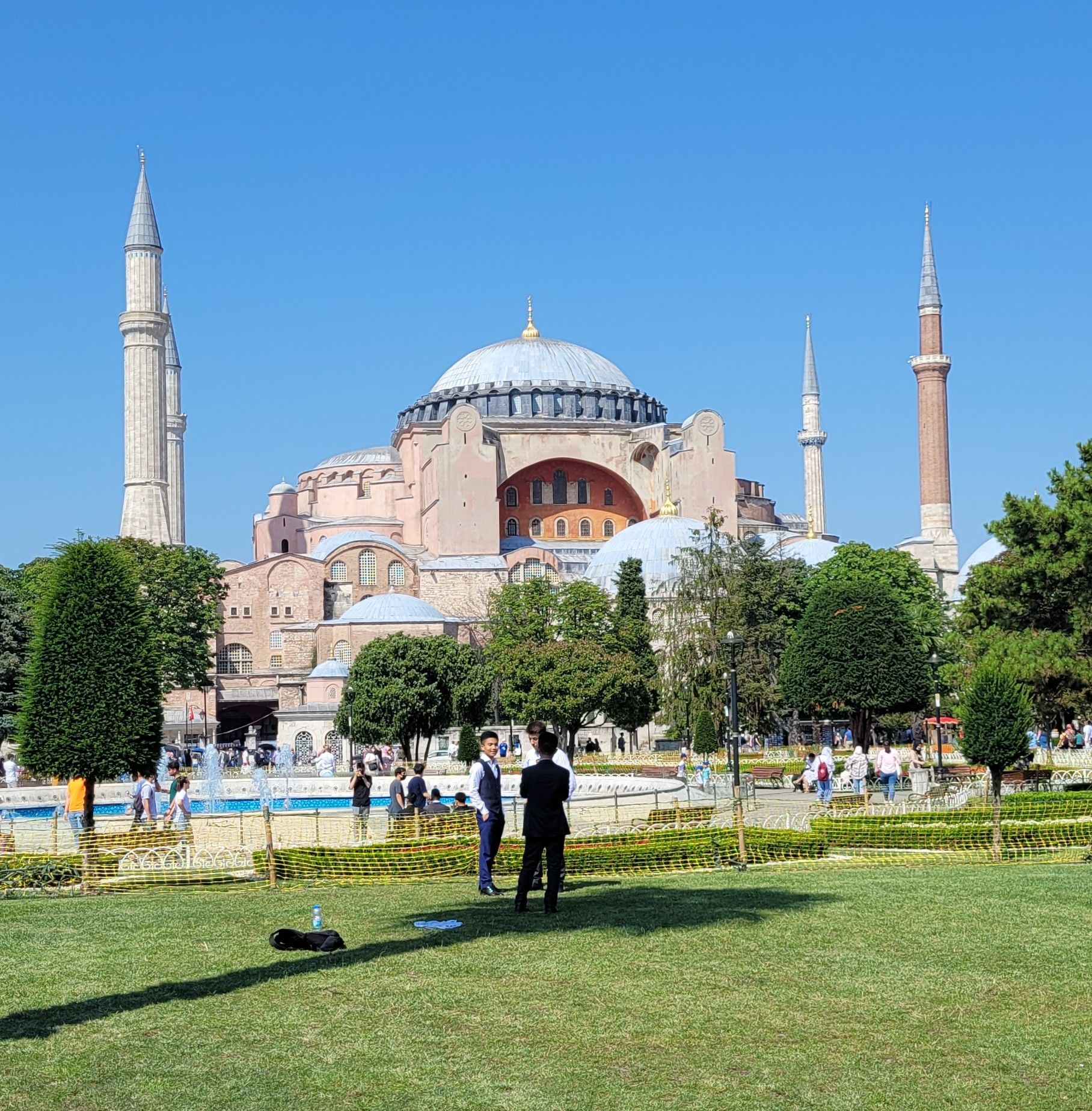 A group of people are standing in front of a large building.