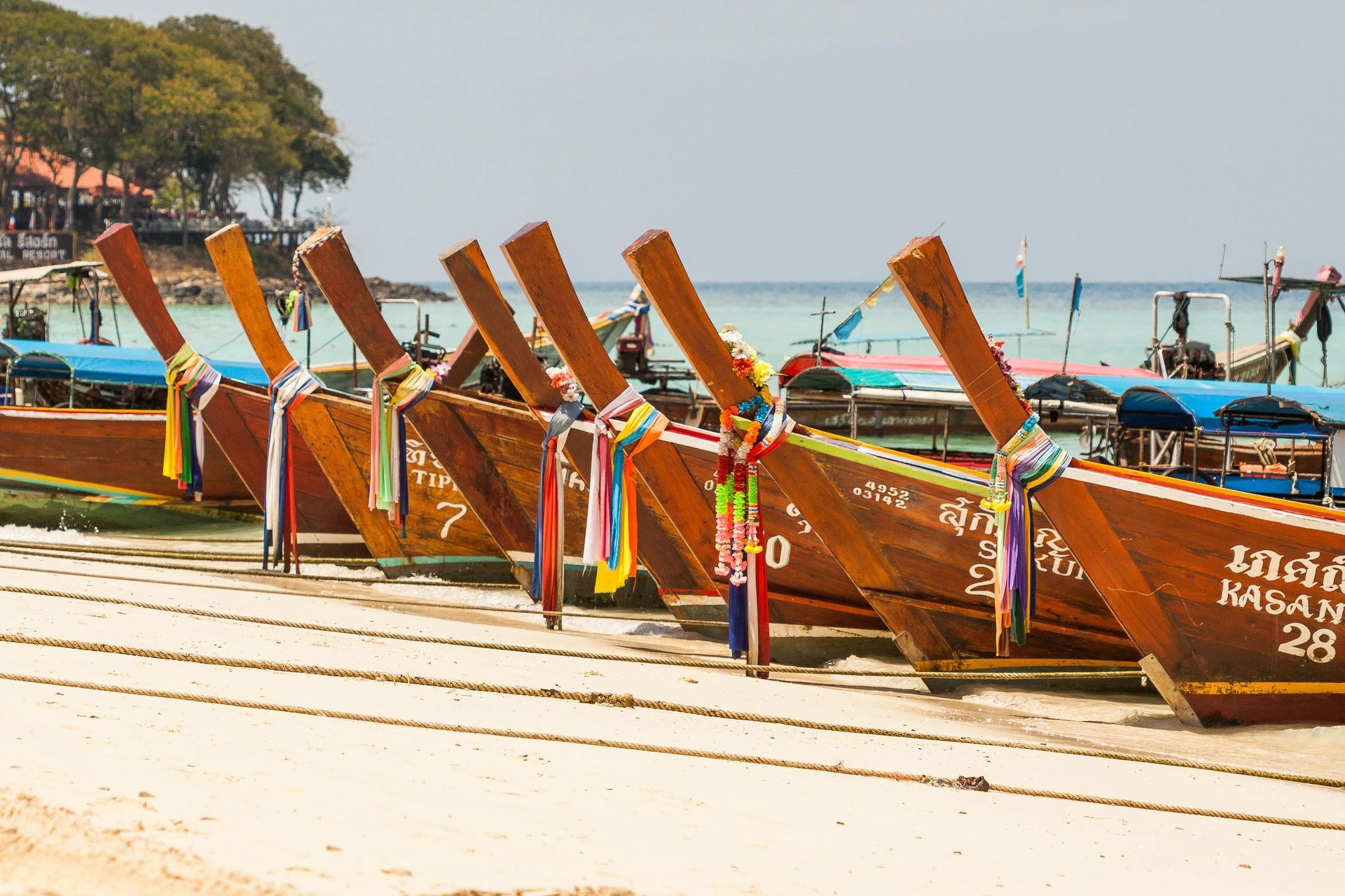 A row of boats are lined up on the beach