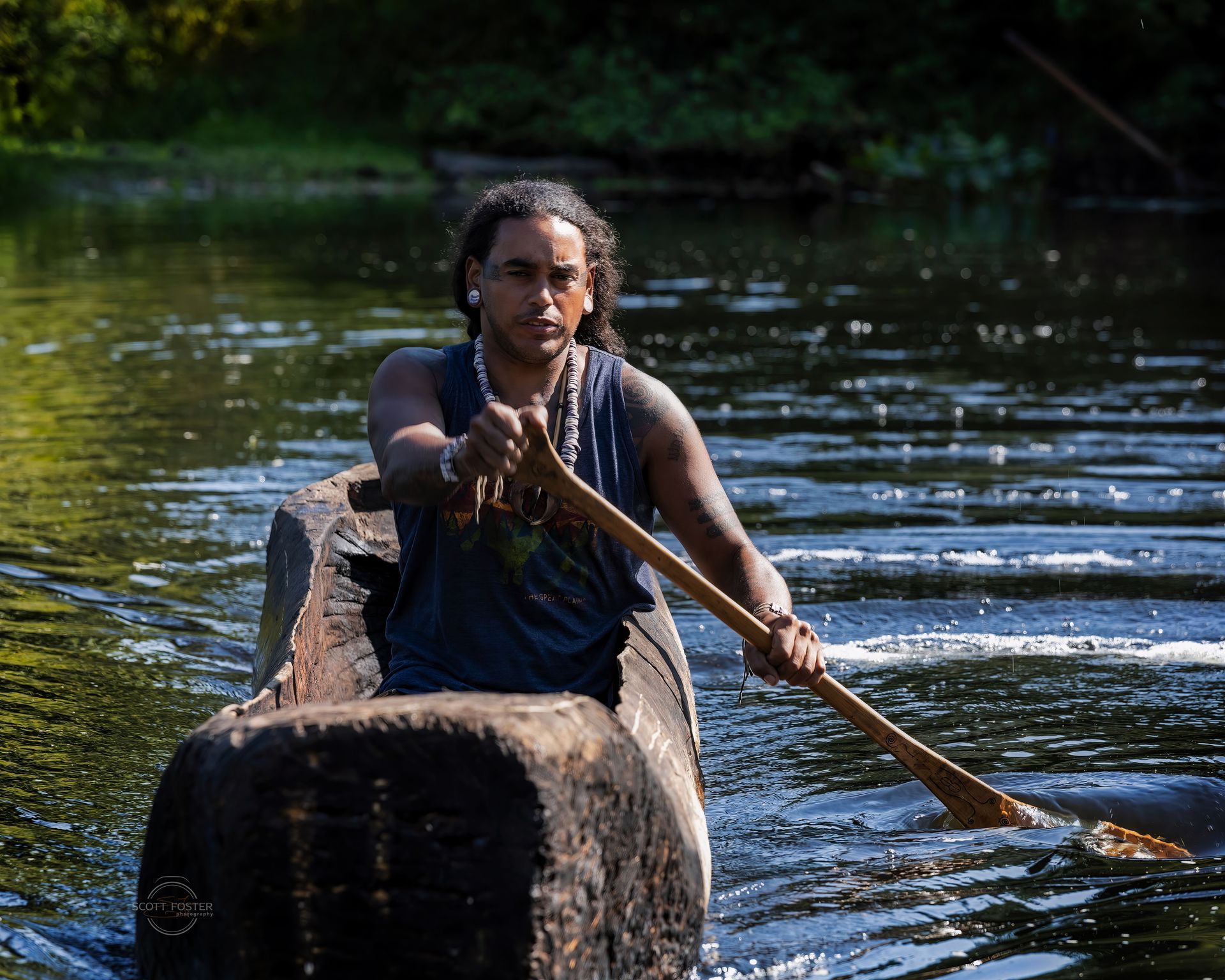Andre Strongbearheart Gaines, Jr.  od the Nipmuc Tribe paddles the freshly created Mishoon at Sudbury's Josephine Pond
