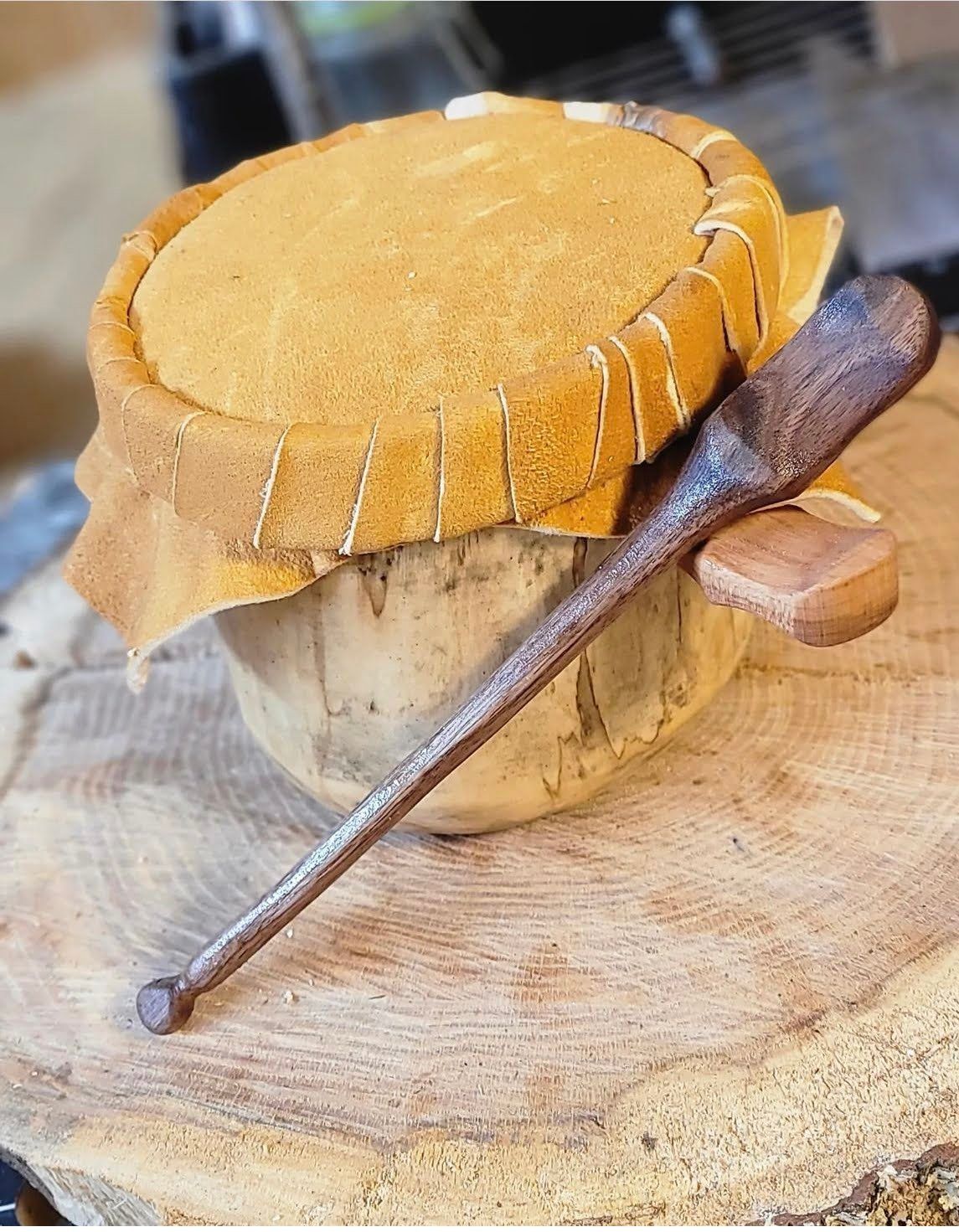 A traditional drum with a small paddle for sale. 