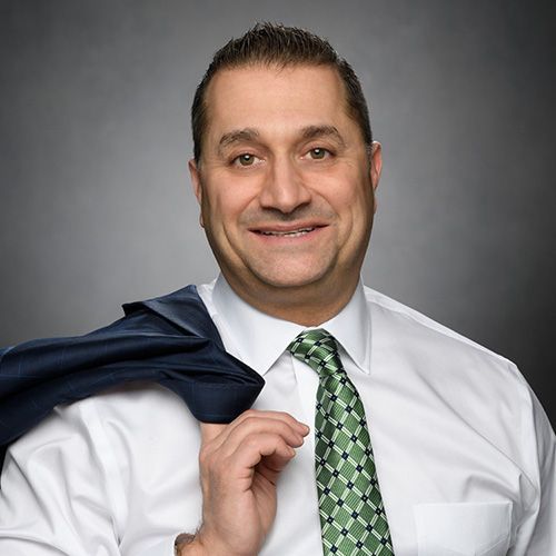 A man and a woman are sitting on a dock overlooking a lake.