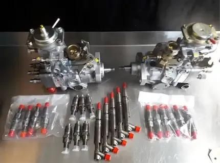 Two Fuel Pumps And Fuel Injectors Are Sitting On A Table — Reef Diesel Injection In North Mackay, QLD