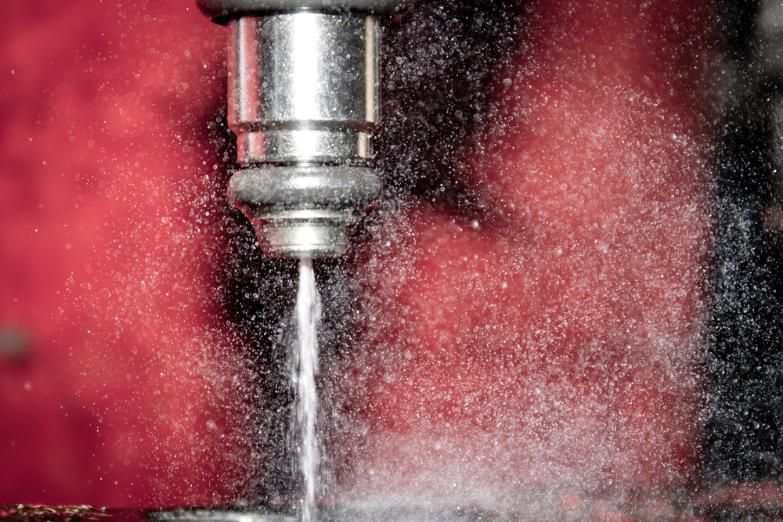 A Close Up Of A Drill Bit With Water Coming Out Of It — Reef Diesel Injection In Moranbah, QLD