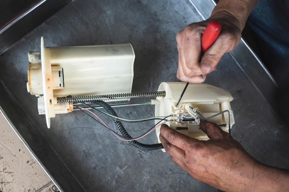 A Person Is Working On A Fuel Pump With A Screwdriver — Reef Diesel Injection In Proserpine, QLD