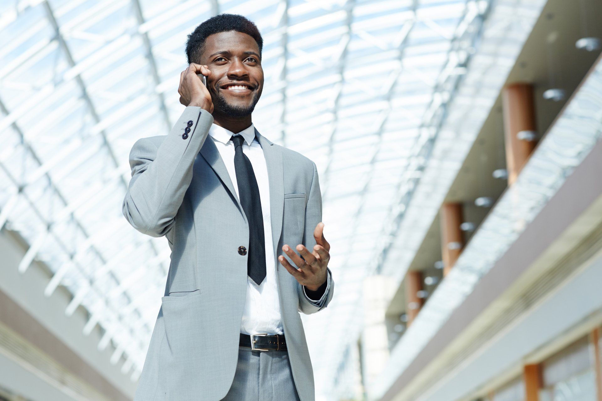 A man in a suit and tie is talking on a cell phone.