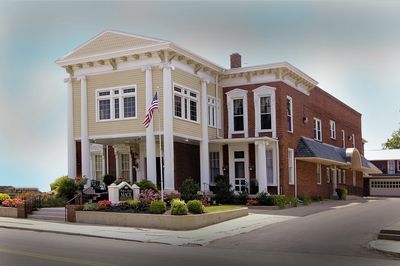 White floral arrangement on a wooden surface, candles in the background.