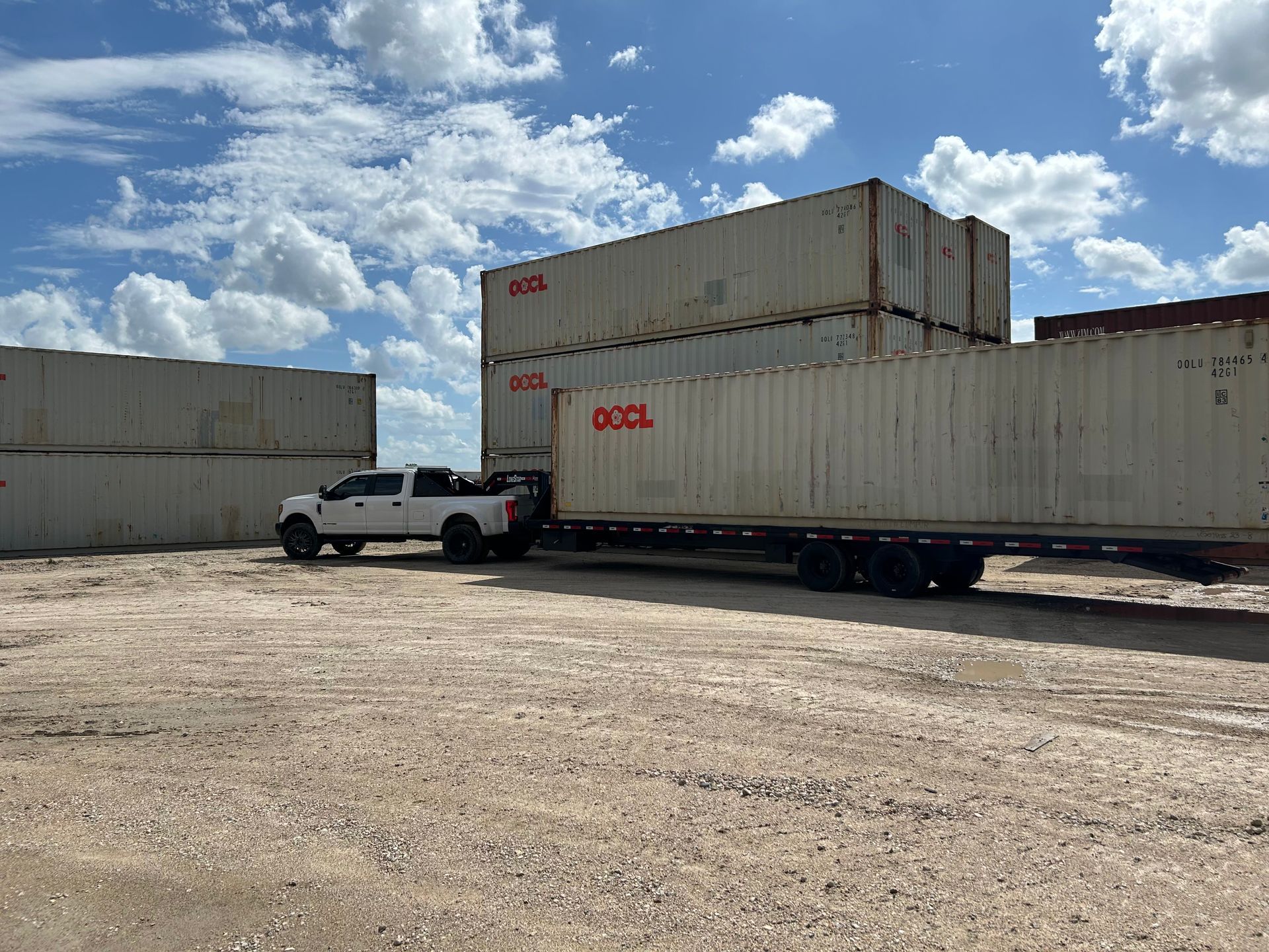 Interior of a shipping container, doors open to show blue container and sunlight.