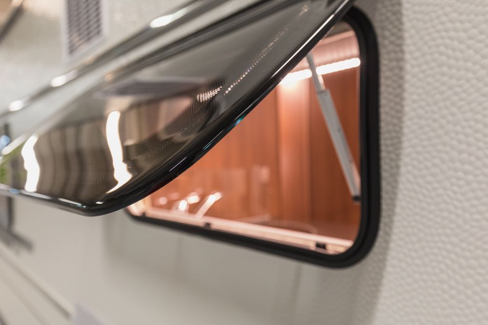 Open Window on a Camper, Showing Interior With Orange Light — Total Caravan Repairs in Taree, NSW