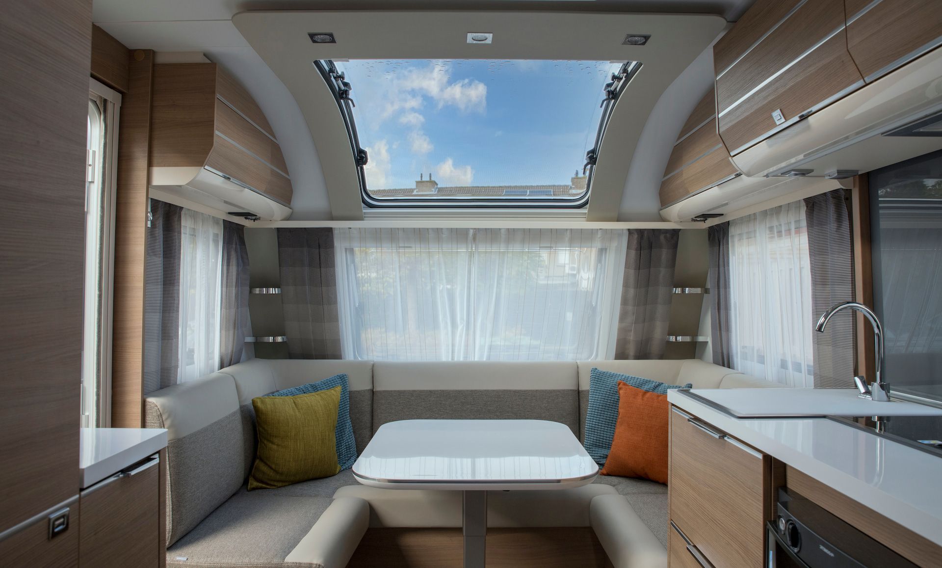 Interior of a Caravan With Seating, a Table, a Kitchen Area, and a Skylight — Total Caravan Repairs in Taree, NSW