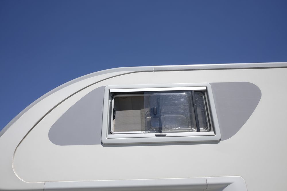 White RV Side With Window Against a Blue Sky — Total Caravan Repairs in Nabiac, NSW