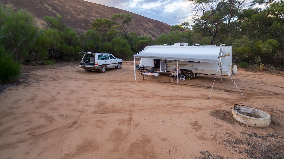 White Camper Trailer and Car Parked in a Sandy Campsite — Total Caravan Repairs in Taree, NSW