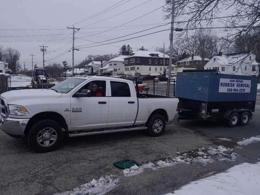 A white truck is pulling a blue trailer on a snowy street.