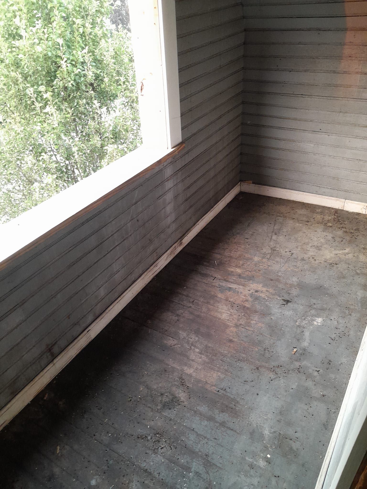 An empty room with a window and a brick wall