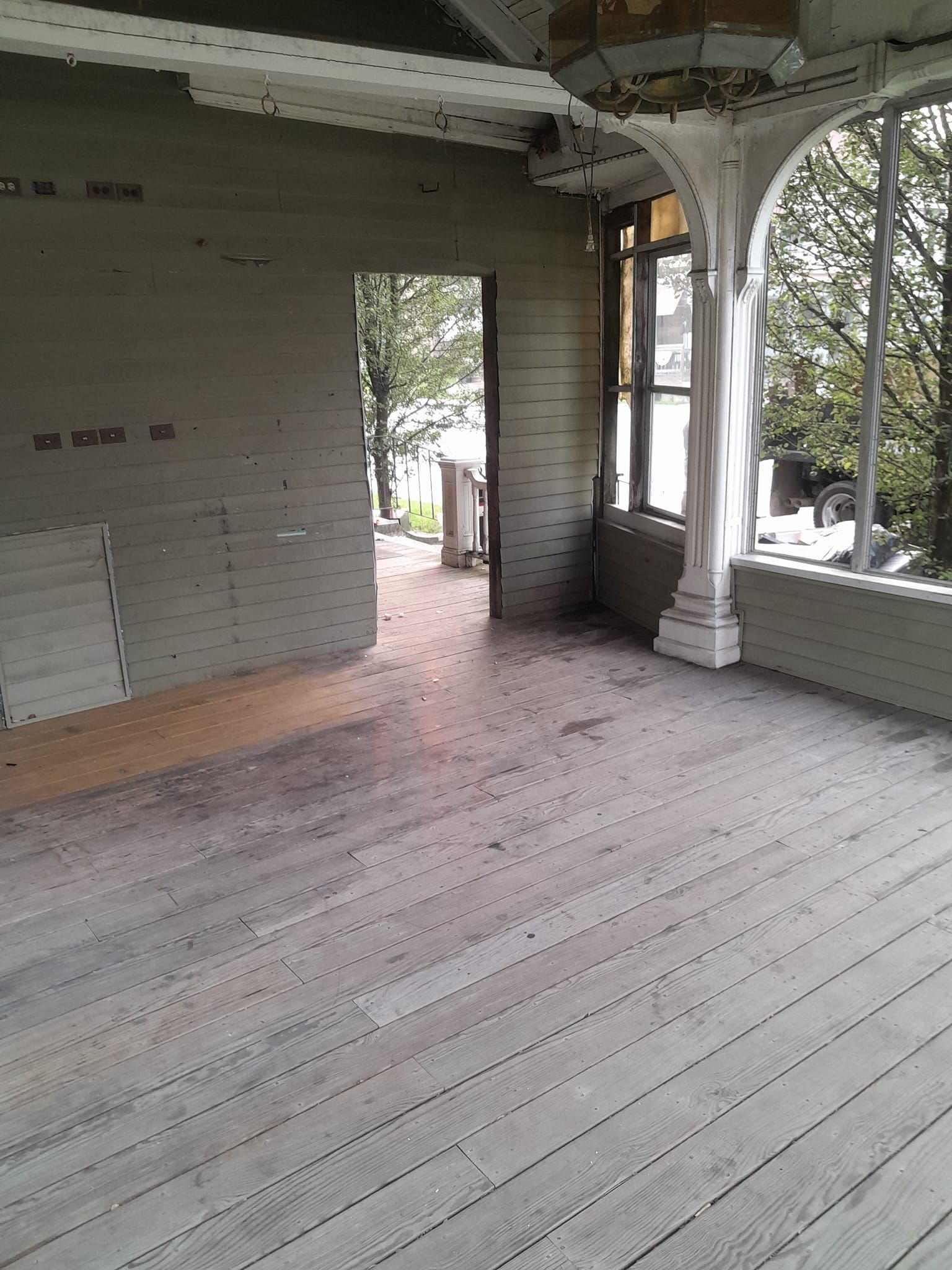 An empty room with a wooden floor and brick walls