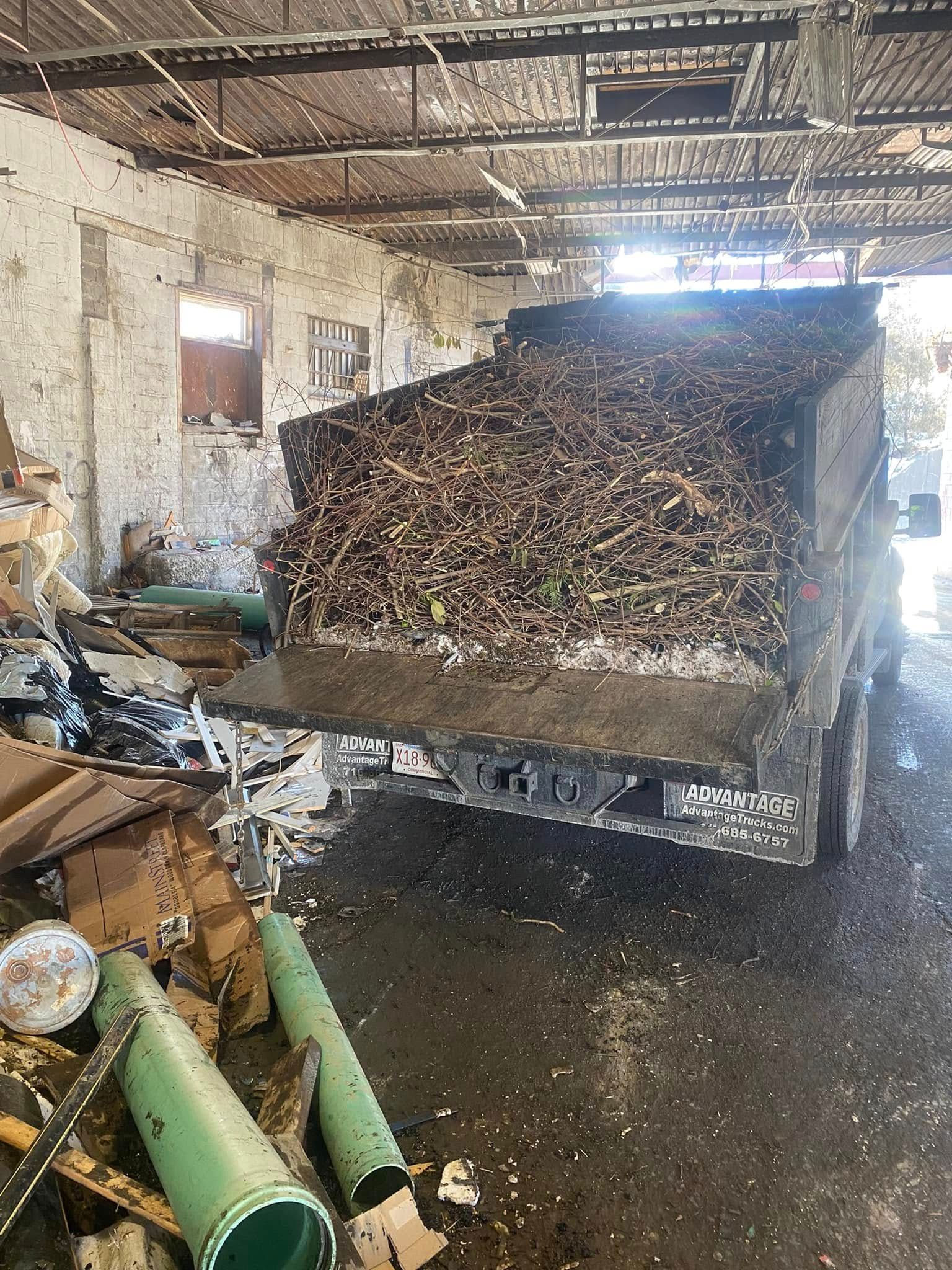 A dump truck is loaded with a pile of wood in a warehouse.