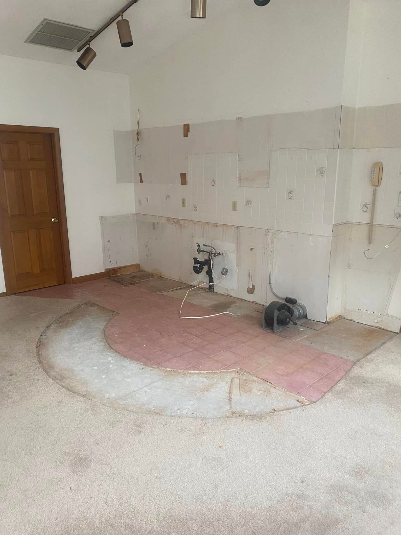 An empty room with a carpeted floor and white walls.