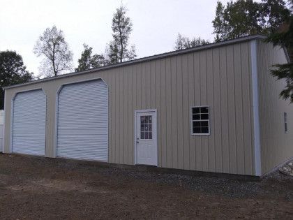 Beige metal garage with two garage doors, a door, and a window.