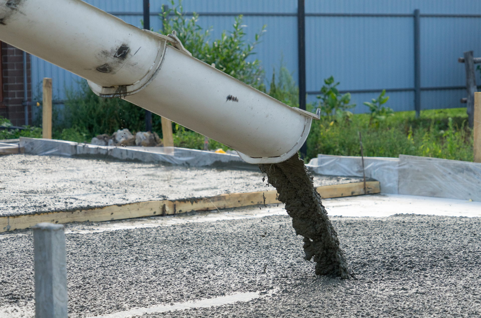A concrete pump is pouring concrete on a construction site.