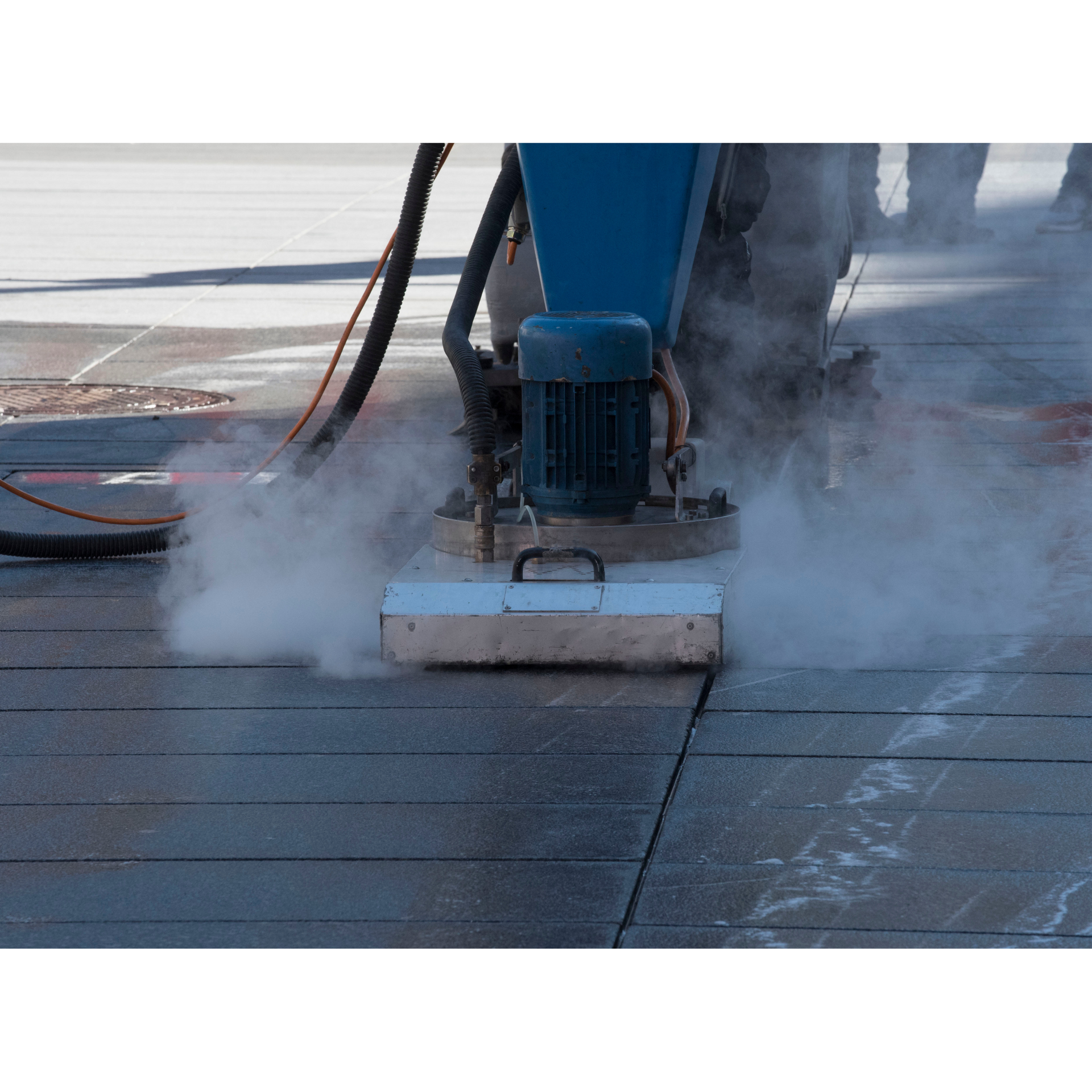 A person is using a machine to clean a concrete floor.