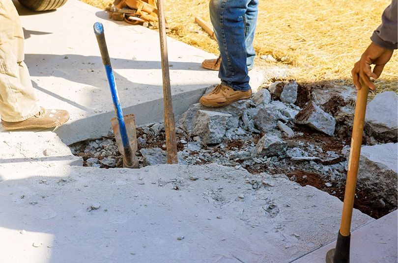 A man is digging a hole in the ground with a shovel.